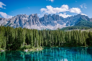 bleu lake in the dolomites italy, carezza lake lago di carezza, karersee with mount latemar, bolzano province, south tyrol, italy. landscape of lake carezza or karersee and dolomites in background