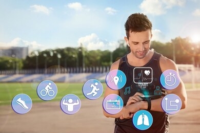 man using smart watch during training outdoors. icons near hand with device