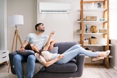happy woman holding air conditioner remote control