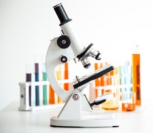 close up of microscope with color solution tubes  on white background.