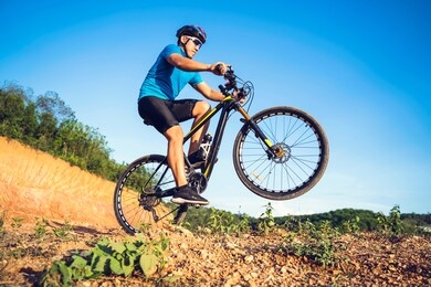 mountain bikes cyclist cycling, asian man athlete riding biking jumping on rocky terrain trail, extreme sport wear gear uniform helmet, exciting freedom outdoor sunset nature healthy active lifestyle