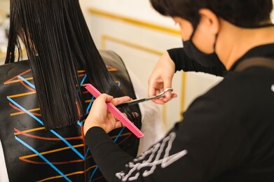 hairdresser giving a new haircut to asia women customer at salon,beautiful cute young plus size female with loose dark hair enjoying