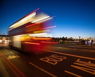 double-decker bus crossing westminster bridge at night in london, england