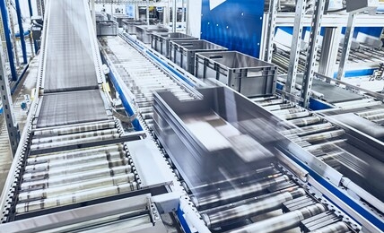 modern roller conveyor system with boxes in motion, shallow depth of field.