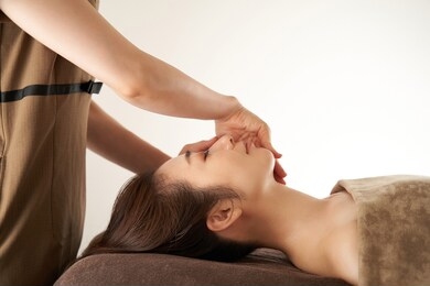 japanese woman receiving a facial massage at an aesthetic salon