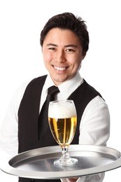 young attractive waiter wearing a white shirt and black vest, serving a nice cold beer. white background.