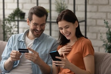 excited millennial couple shopping online pay with credit card feel euphoric with discount or sale, smiling young man and woman clients make payment purchase on internet, secure service concept