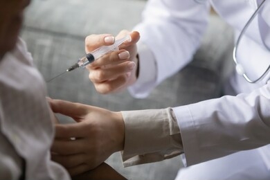 close up young general practitioner making vaccination treatment injection to older mature male patient at hospital clinic, disease prevention, illness treatment, medical service healthcare concept.