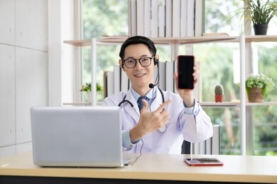 asian doctor showing a blank smart phone