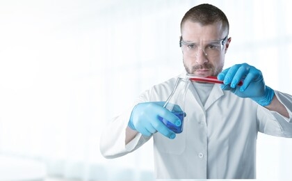 laboratory researcher holding medical glass bottle with liquid wearing sterile gloves