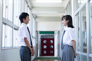junior high school students standing facing each other in the corridor