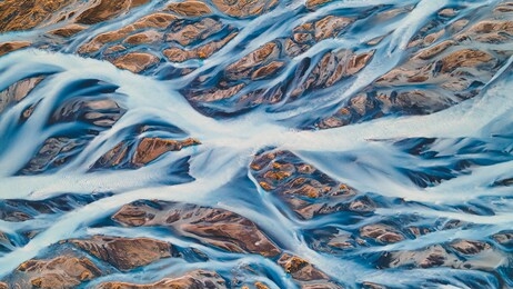 a glacial rivers from above. aerial photograph of the river streams from icelandic glaciers. beautiful art of the mother nature created in iceland. wallpaper background high quality photo