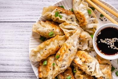 fried dumplings gyoza with soy sauce, and chopsticks, top view.