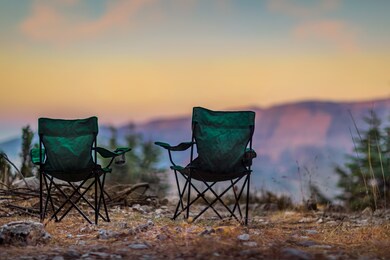 two empty camping chairs standing on the top of the mount. perfect place for watching sunset. actice relaxation lifestyle