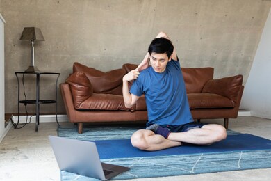 man exercising at home in front of laptop