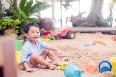 3.7 years old asian toddler boy play slide in playground.happy boy child laughing and smile.enjoying time in the park outdoor.handsome toddler boy play.kindergarten kid.child development.ef eq concept