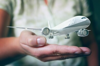 a plane airliner over woman's hands in a protective position. aircraft industry concepts, airline safety and insurance 