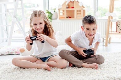 little boy and girl playing video game