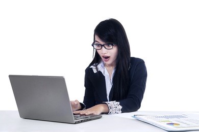 young businesswoman shocked and looking at laptop screen