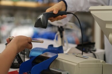 close up hand holding phone to scan the code to pay at checkout. scan the qr code to pay. contactless payment. soft focus