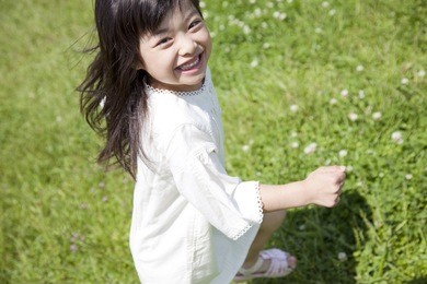 japanese girl smiling and running in grass