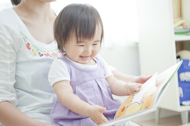 japanese girl reading a picture book to her mother,
