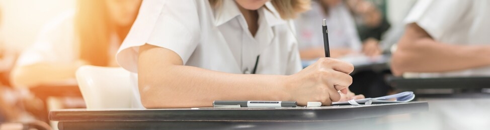 exam at school with student's taking educational admission test in class, thinking hard, writing answer in university classroom, education and world literacy day concept