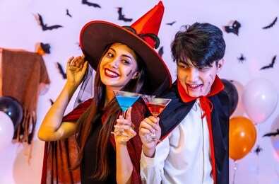 asian happy friends in costumes and makeup on a celebration of halloween drinking cocktails and having fun in party, celebration of halloween.