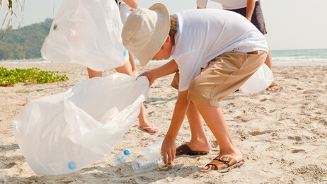 asian young happy family activists collecting plastic waste on beach. asia volunteers help to keep nature clean up and pick up garbage. concept about environmental conservation pollution problems.
