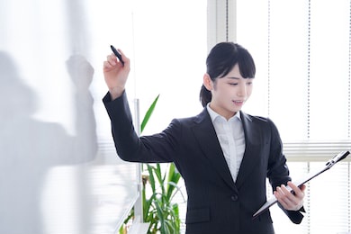 japanese woman writing on a whiteboard