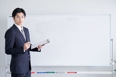 japanese male businessman explaining to the audience using a white board for text synthesis