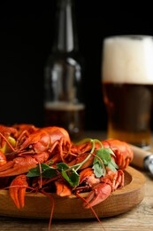 delicious red boiled crayfishes and beer on wooden table, closeup