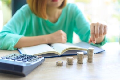 asian female put the coin into coin stack. money saving concept