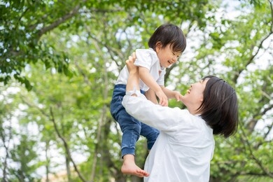 a young mother and son enjoy a picnic together in a park.