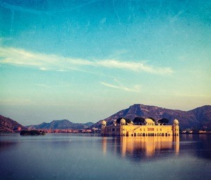 vintage retro hipster style travel image of rajasthan landmark - jal mahal (water palace) on man sagar lake on sunset with grunge texture overlaid.  jaipur, rajasthan, india