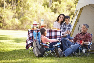 family enjoying camping holiday in countryside