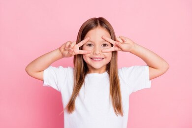 photo of nice adorable pretty kid enjoy spring free time make v-sign wear good look clothes isolated over pink color background