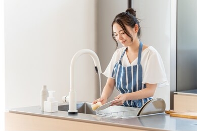 portrait of attractive asian woman washing dish at kitchen