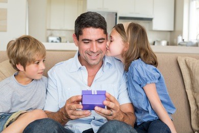 loving children gifting father in living room
