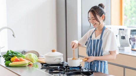 attractive asian woman cooking at kitchen