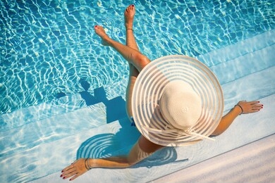 woman sitting on the stairs of a luxury five stars  spa resort  swimming pool. 
