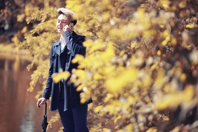 autumn park in rainy weather and a young man with an umbrella
