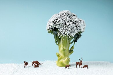 broccoli representing winter tree with snow and miniature deer. christmas background for holiday seasonal festive party celebration with healthy food decoration. minimal winter concept.