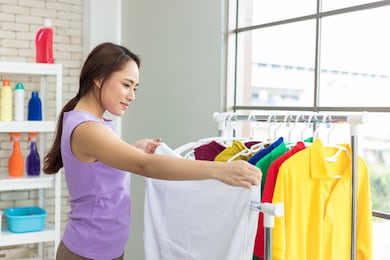 housewife is drying clothes on the clothesline after laundry. asian young woman is happily doing housework.