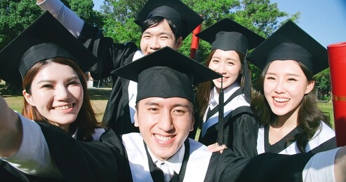 closeup of group happy graduates students use mobile phone to take selfie together