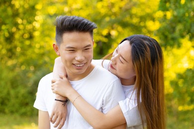 young couple in love smiles and strolls in the park hugging each other tenderly
