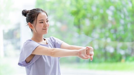 attractive asian woman stretching at living room