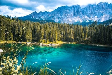 lago di carezza lake or the karersee with reflection of mountains in the dolomite alps, dolomites, south tyrol, italy.