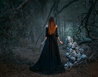 mysterious silhouette of a ghost woman in a black vintage long dress. gothic pagan lady near many skulls of dead people. the vampire walks in a deep dark mystical forest. back rear view.