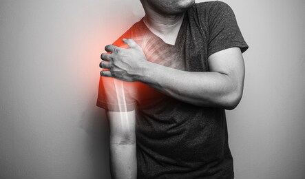 close up shoulder and clavicle fracture pain in a man, young man holding his shoulder in pain  shoulder  inflammation symptoms medical healthcare concept.